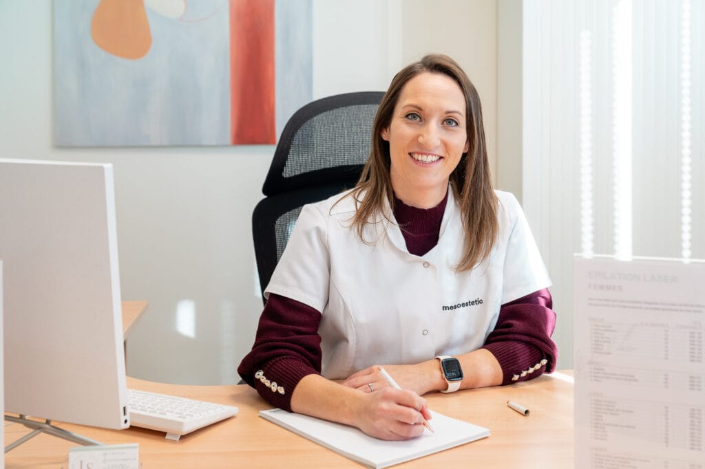 Praticienne en épilation laser à Béziers, assise à son bureau en cabinet esthétique